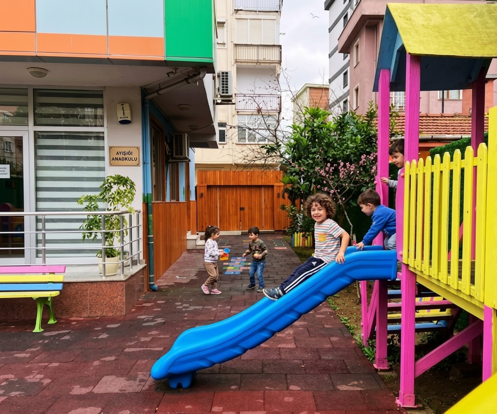 Ayışığım Anaokulu bahçesinde oyun parkında gülümseyen çocuklar